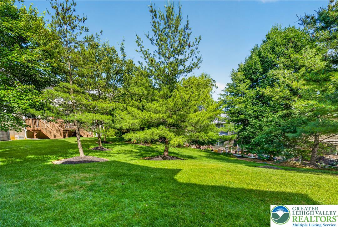 4345 Creek Road Allentown, PA 18104 - Photo 31 of 33 A well-maintained lawn and verdant trees provide a natural, tranquil backdrop to the home's exterior deck.