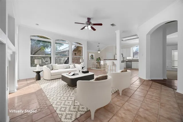 a living room with patio furniture and a large window