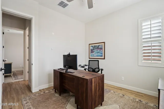 a view of a workspace with furniture and a window