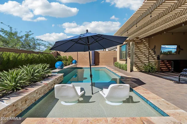 a view of a white house with a small yard and potted plants