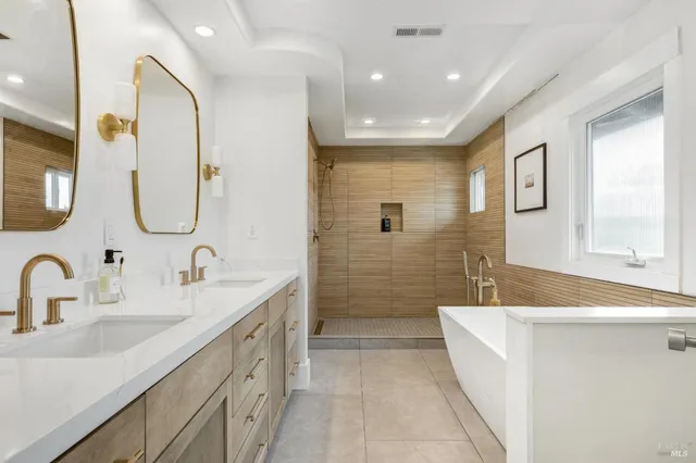 a spacious bathroom with a double vanity sink a mirror and a bathtub