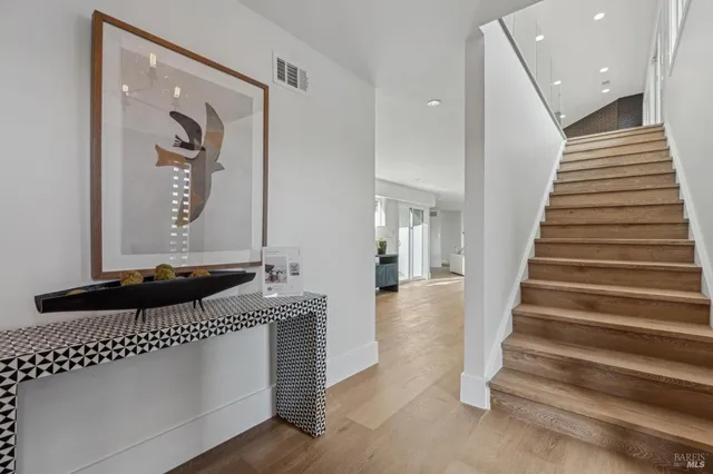 a view of entryway and hall with wooden floor
