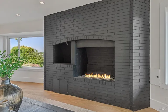 a living room with a fireplace and a potted plant