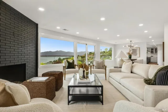 a living room with furniture fireplace and a large window
