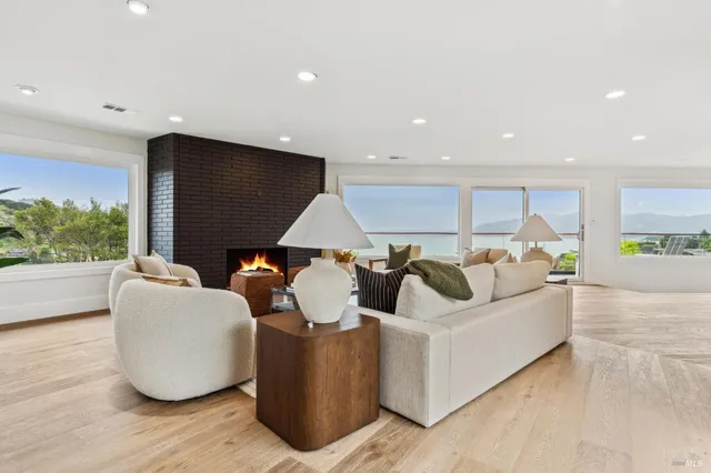 a living room with furniture kitchen view and a large window