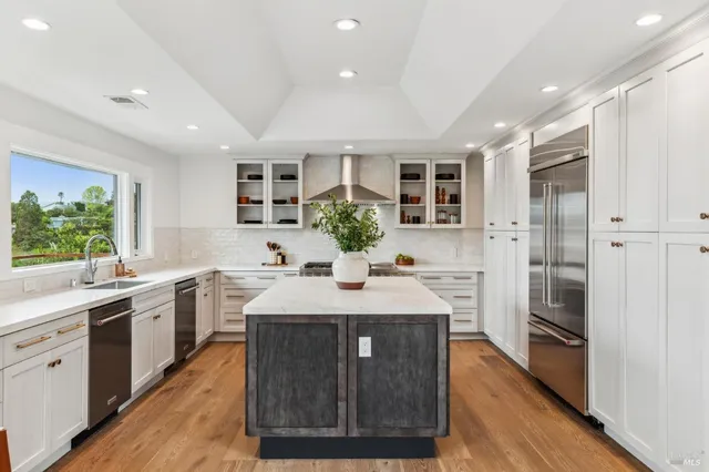 a kitchen with kitchen island granite countertop a sink and refrigerator