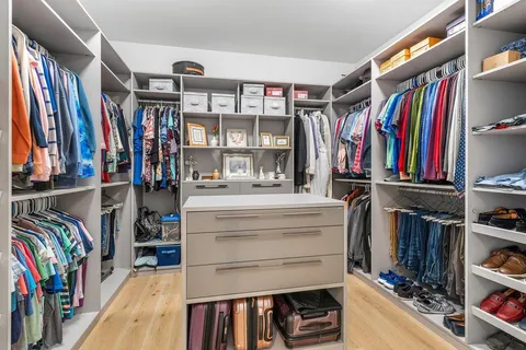 a view of walk in closet with clothes and shoes