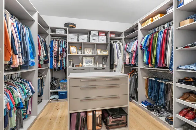 a view of walk in closet with clothes and shoes