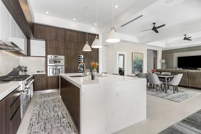 a large white kitchen with a stove and a sink