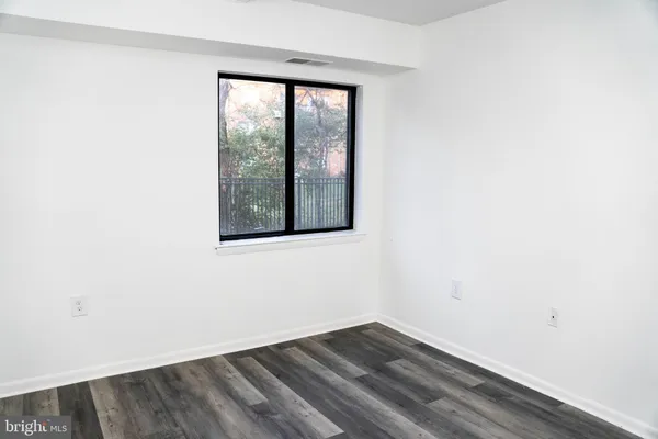 a view of a small space with wooden floor and a window