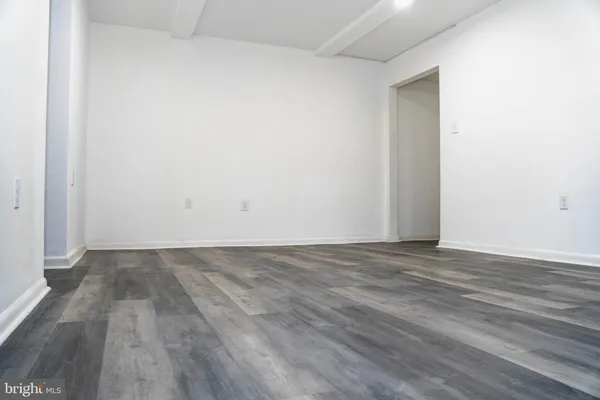 a view of a hallway with wooden floor and closet