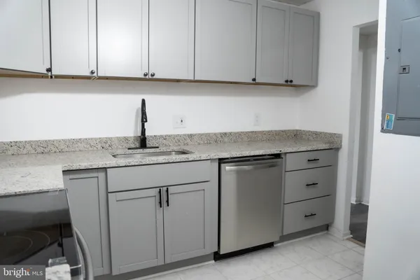 a kitchen with granite countertop white cabinets and a sink