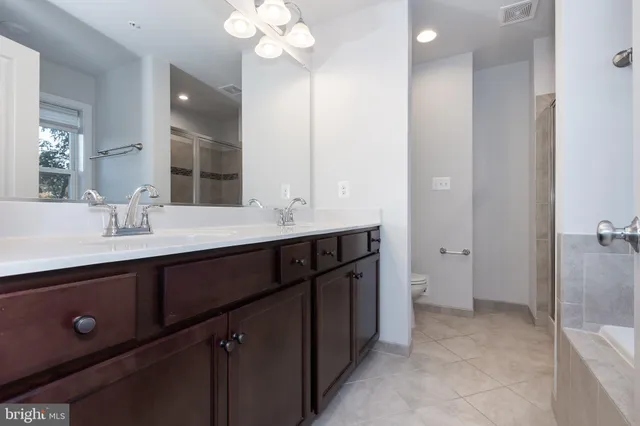 a bathroom with a double vanity sink a mirror and a shower