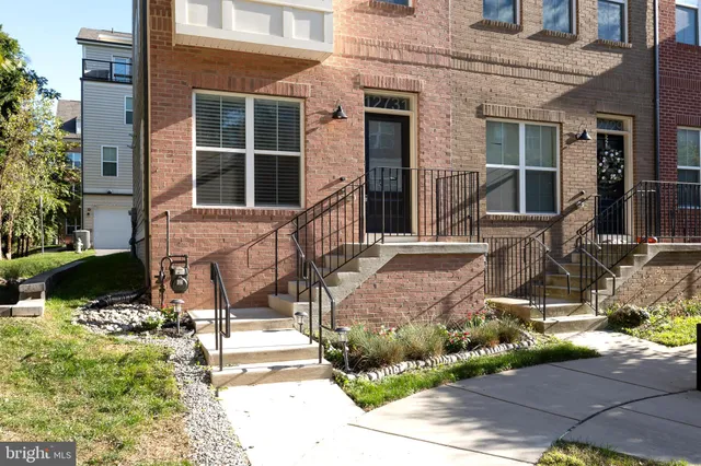 a front view of a house with glass windows and plants