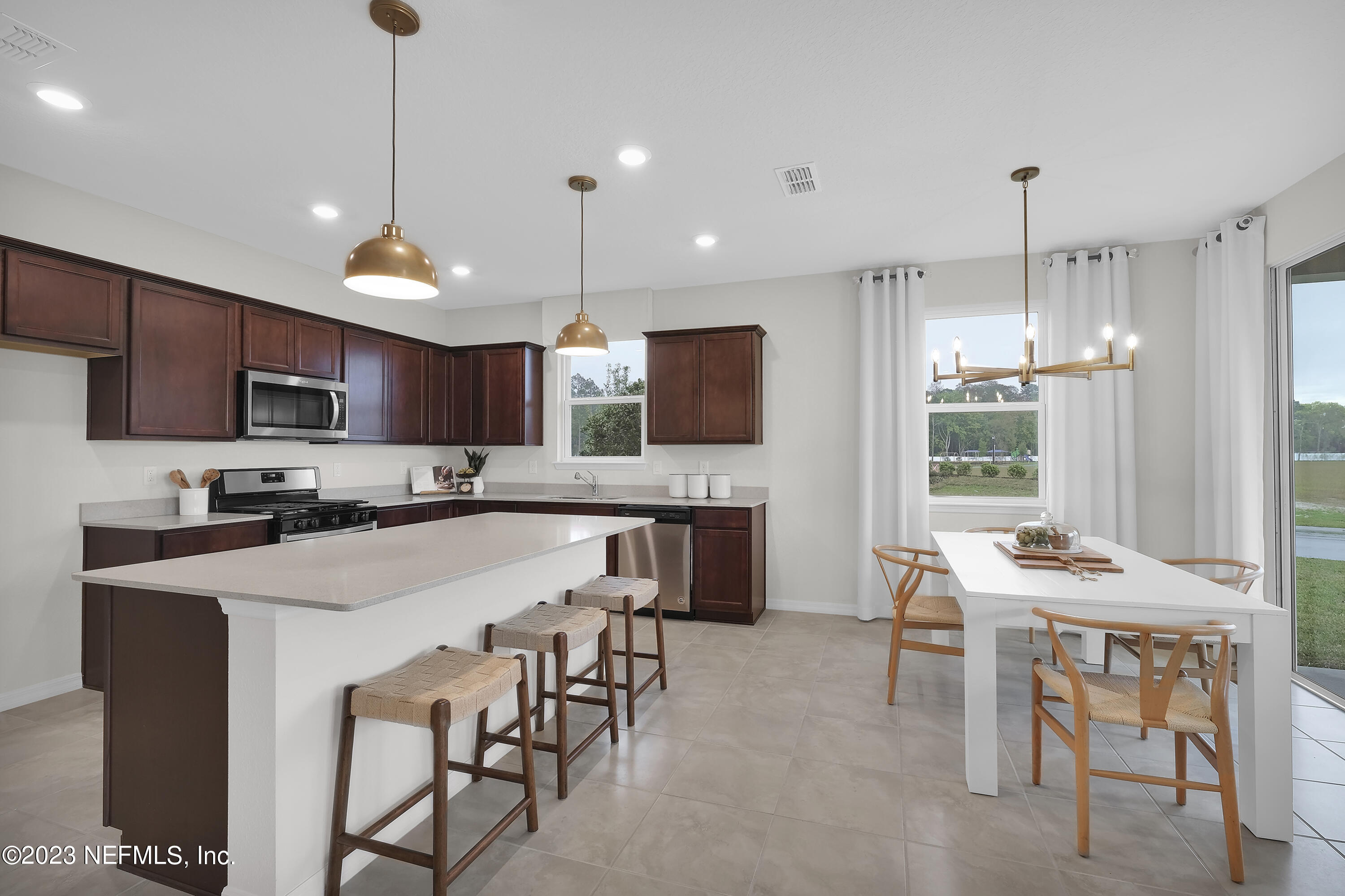 127 Shell Crk Court St. Augustine, FL 32086 - Photo 8 of 21 a kitchen with stainless steel appliances a table chairs refrigerator and microwave