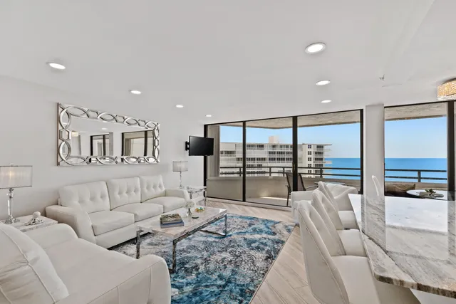 a living room with furniture floor to ceiling window and wooden floor