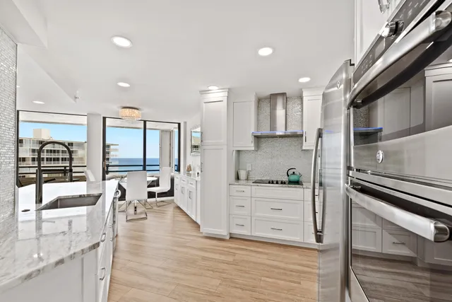 a kitchen with stainless steel appliances kitchen island granite countertop a stove refrigerator and cabinets