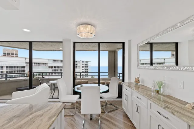 a large white kitchen with a large window and stainless steel appliances