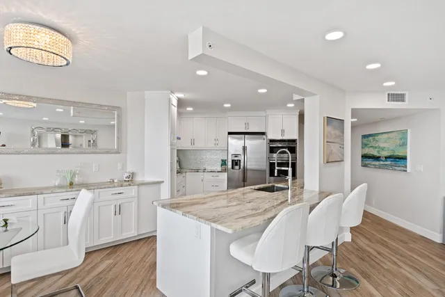 a large kitchen with kitchen island a dining table and chairs