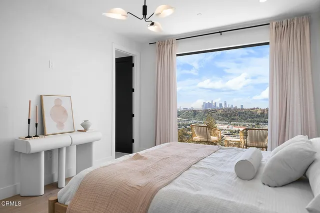 a bedroom with a large bed and a chandelier