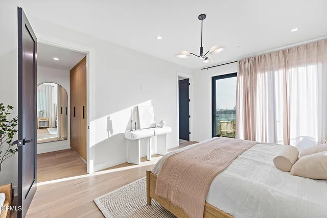 a bedroom with a bed and a flat tv screen on the dresser