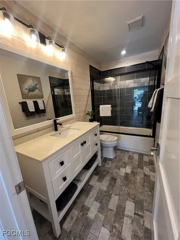a bathroom with a double vanity sink toilet and mirror
