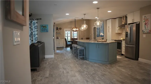 a kitchen with kitchen island a counter top space appliances and a living room view