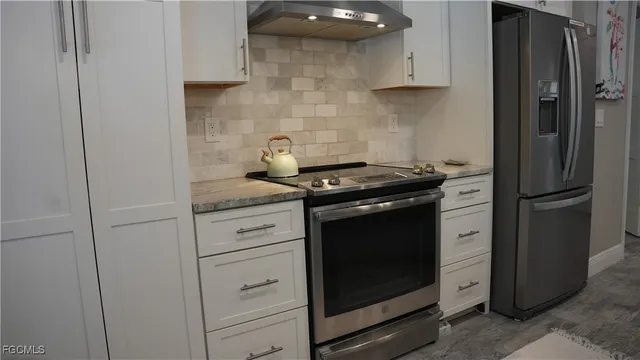 a kitchen with stainless steel appliances white cabinets and a refrigerator