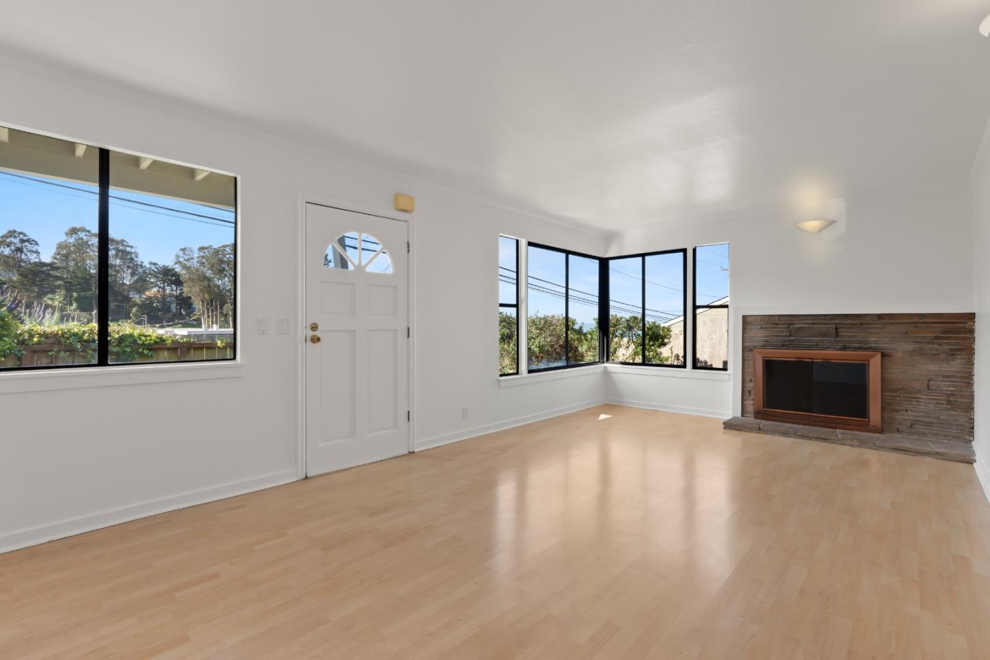 443 Monterey Road Pacifica, CA 94044 - Photo 6 of 26 a view of an empty room with a fireplace and a window