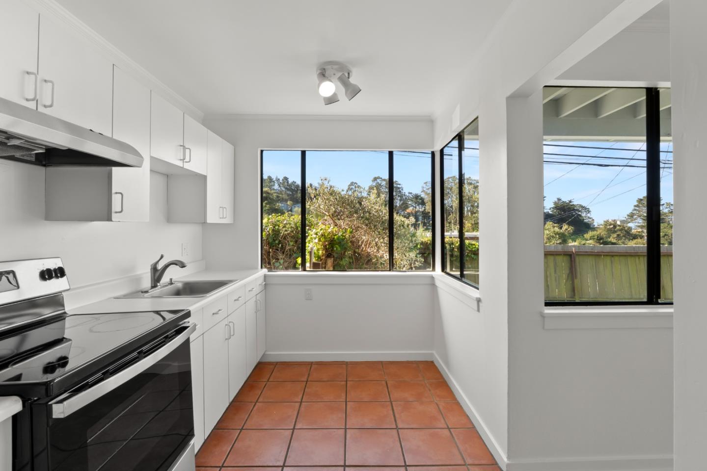 443 Monterey Road Pacifica, CA 94044 - Photo 10 of 26 a kitchen with a sink a stove and cabinets