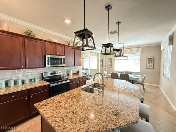 a kitchen with stainless steel appliances granite countertop a sink a stove and a wooden floors