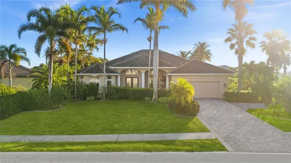 a view of a white house with a yard and potted plants
