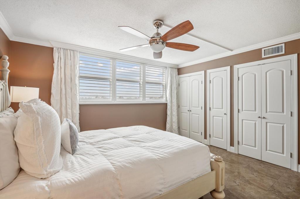 303 North Riverside Drive, Unit 403 Pompano Beach, FL 33062 - Photo 11 of 31 a bedroom with a large bed and a chandelier