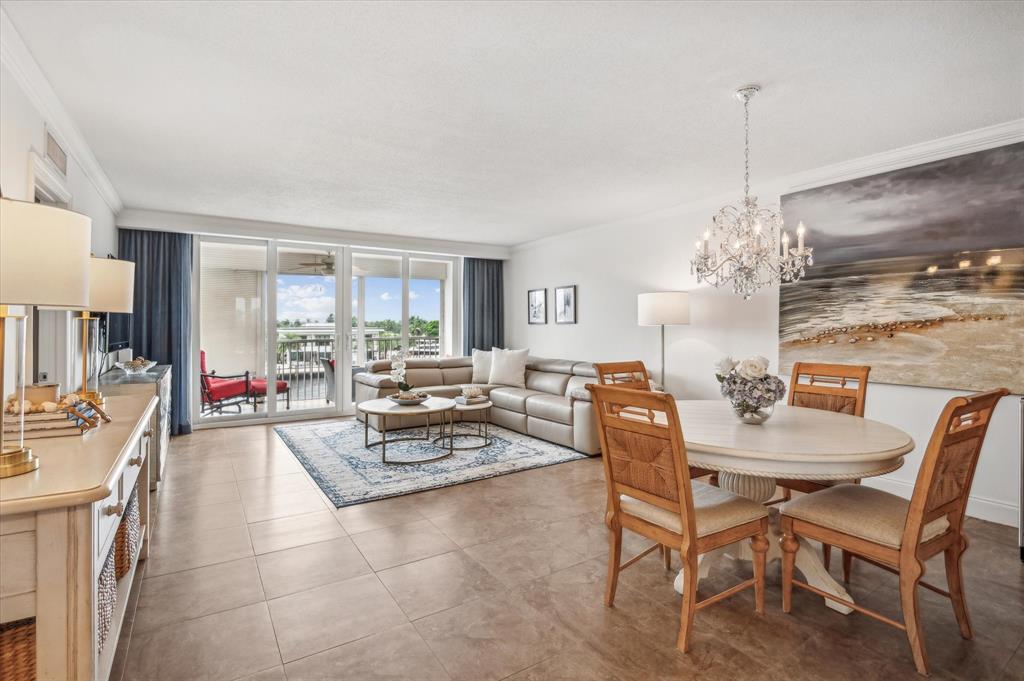 303 North Riverside Drive, Unit 403 Pompano Beach, FL 33062 - Photo 3 of 31 a living room with furniture a chandelier and a dining table