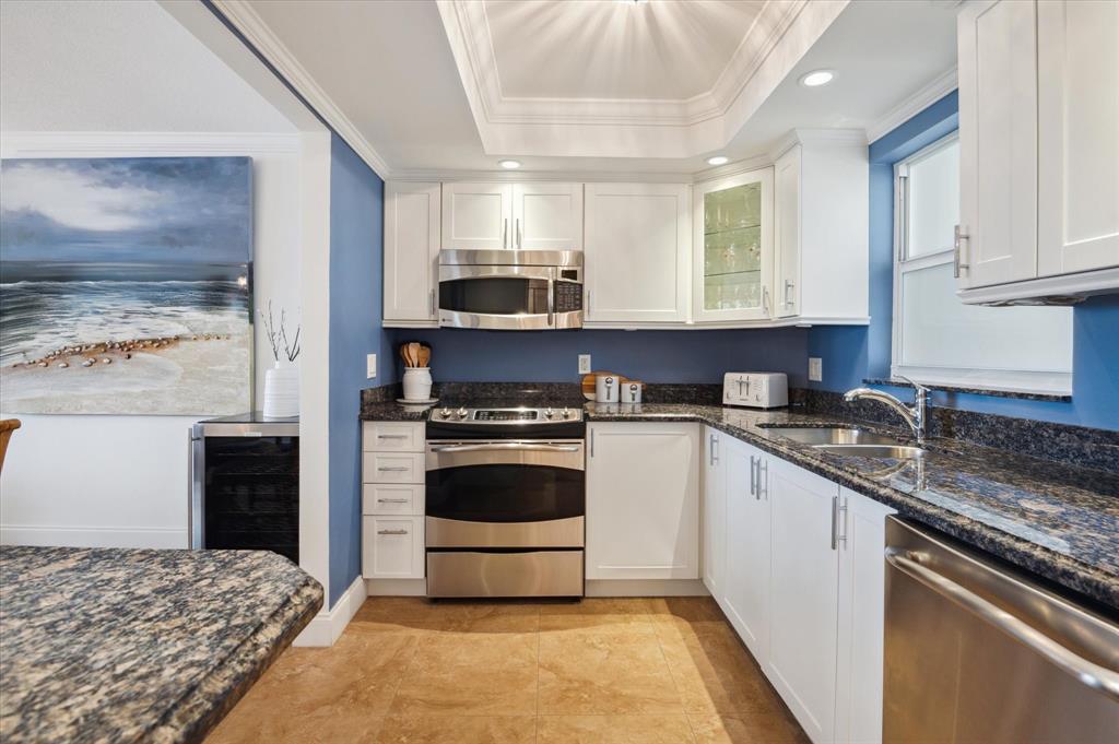 303 North Riverside Drive, Unit 403 Pompano Beach, FL 33062 - Photo 9 of 31 a kitchen with stainless steel appliances granite countertop a stove a sink and a refrigerator