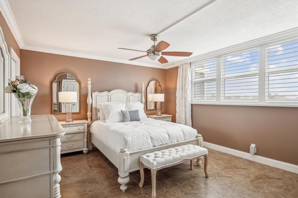 303 North Riverside Drive, Unit 403 Pompano Beach, FL 33062 - Photo 10 of 31 a bedroom with a large bed and a chandelier