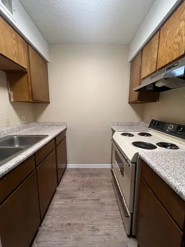 a kitchen with a sink stove top oven and cabinets