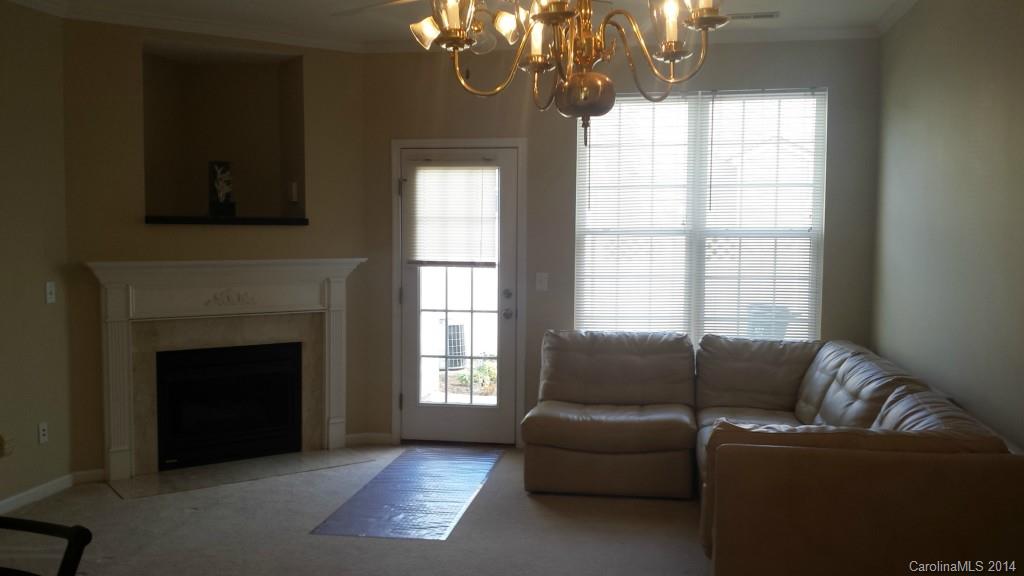 725 Shellstone Place, Unit 55 Fort Mill, SC 29708 - Photo 2 of 7 a living room with furniture a chandelier and a fireplace