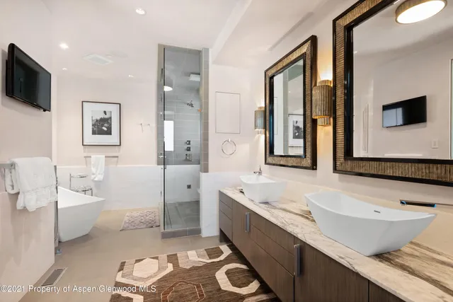 a spacious bathroom with a double vanity sink a mirror and a bathtub