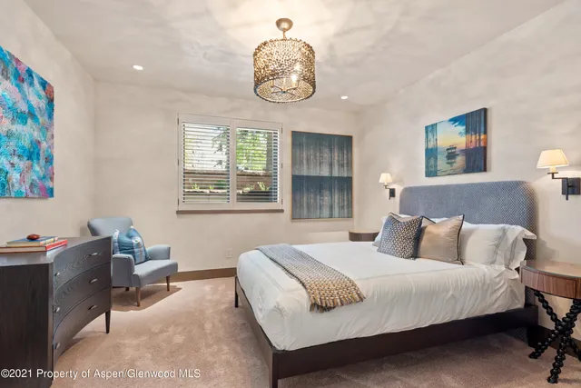 a bedroom with a bed and a chandelier