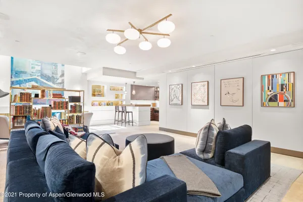 a living room with furniture kitchen view and a large window