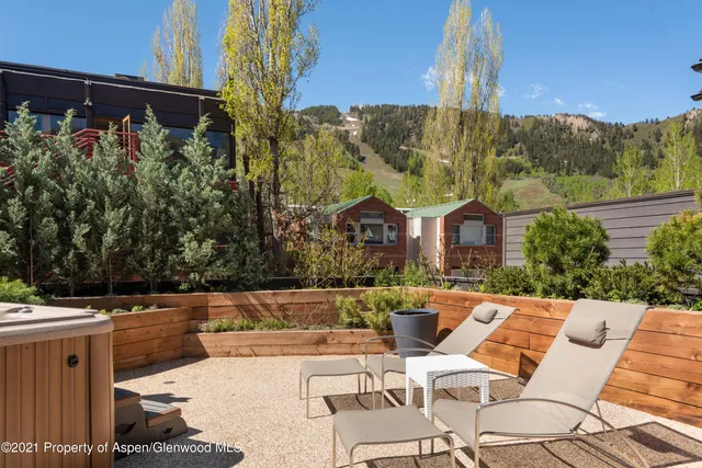a view of a patio with couches table and chairs and potted plants