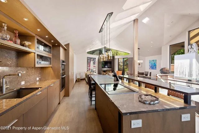 a kitchen with stainless steel appliances granite countertop a sink a stove and a wooden cabinets