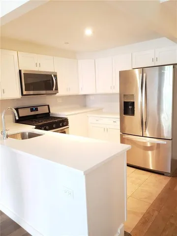 a kitchen with stainless steel appliances a refrigerator stove microwave and sink