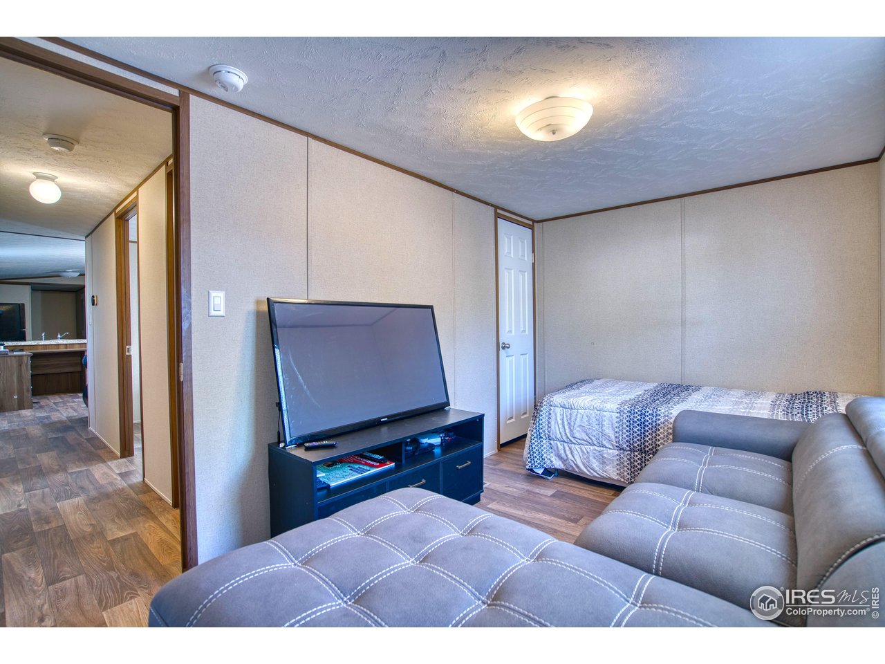 218 Grape Street, Unit 28 Hudson, CO 80642 - Photo 11 of 17 a living room with furniture and a flat screen tv