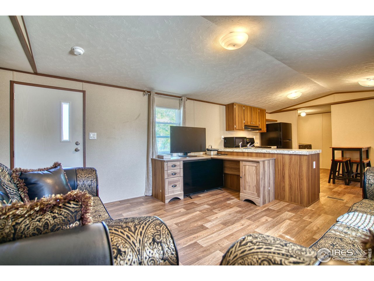 218 Grape Street, Unit 28 Hudson, CO 80642 - Photo 2 of 17 a bedroom with a bed and a television