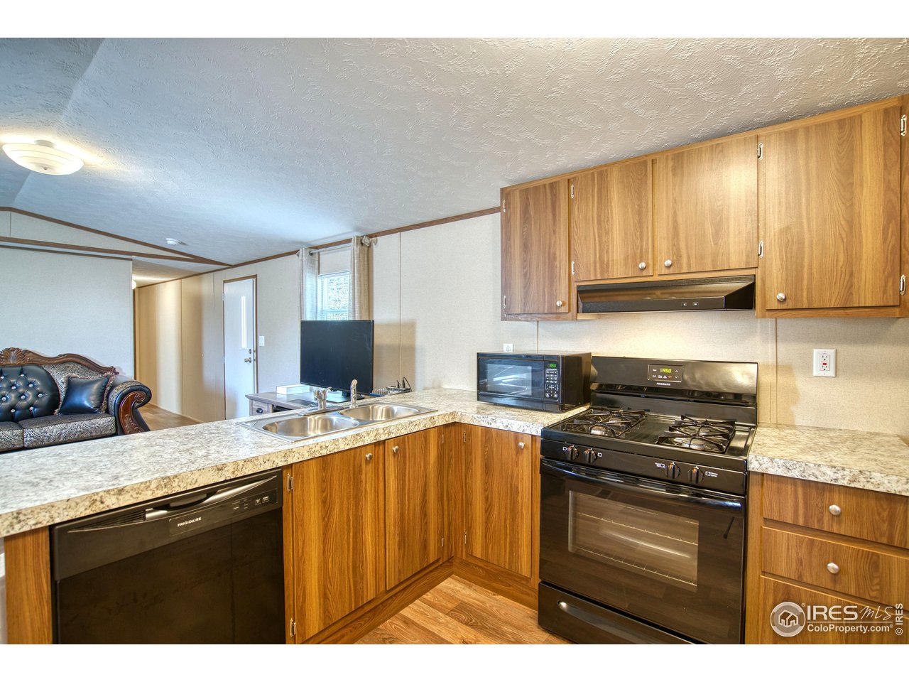 218 Grape Street, Unit 28 Hudson, CO 80642 - Photo 4 of 17 a kitchen with a sink stove and cabinets