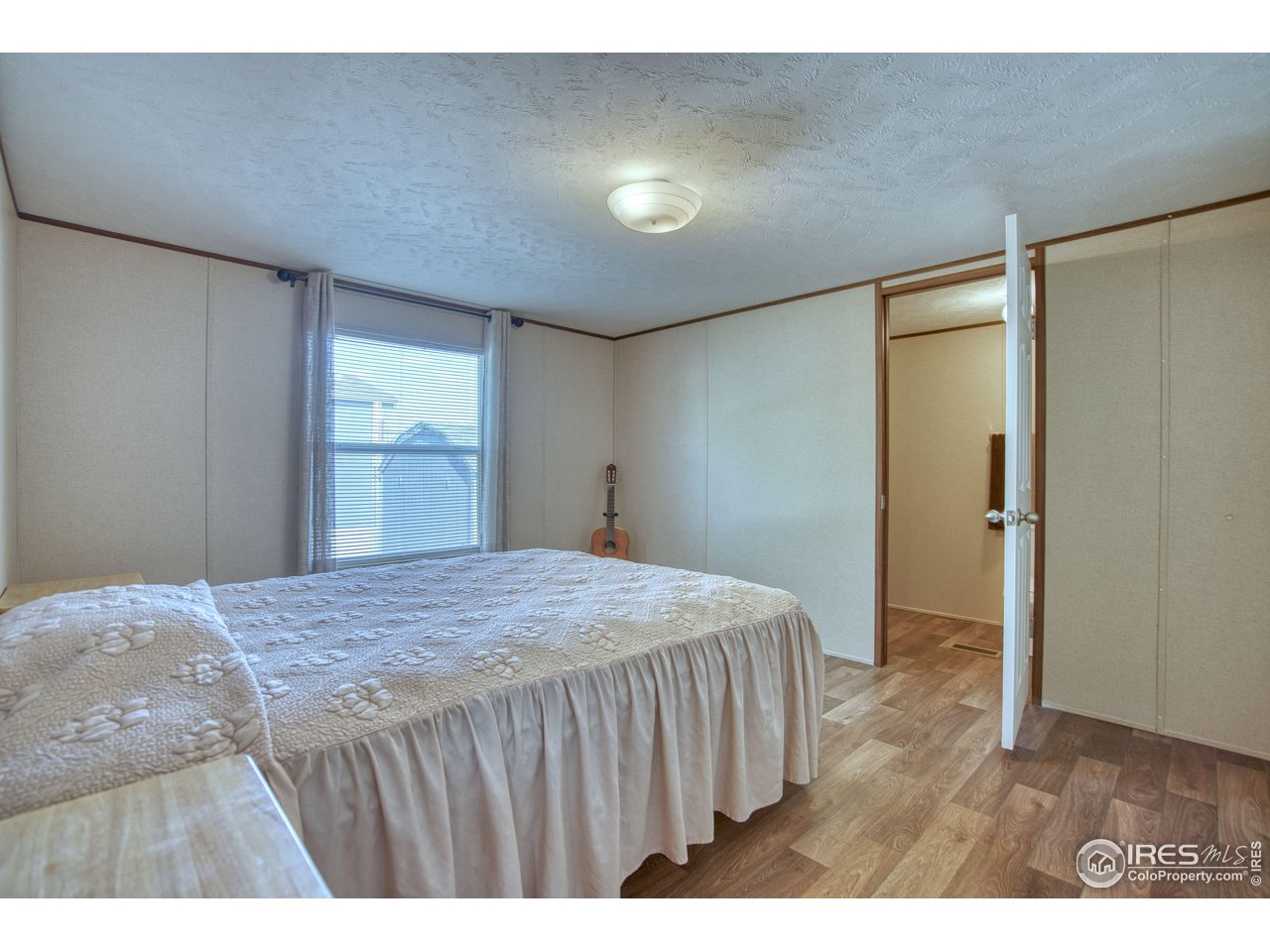218 Grape Street, Unit 28 Hudson, CO 80642 - Photo 7 of 17 a bedroom with a bed and a dresser
