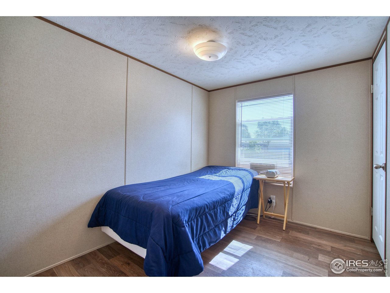 218 Grape Street, Unit 28 Hudson, CO 80642 - Photo 10 of 17 a bedroom with a bed and a chandelier