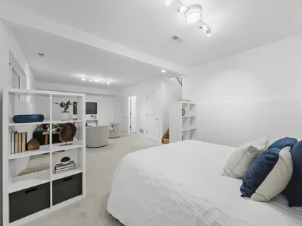 a large bedroom with a bed and a view of living room